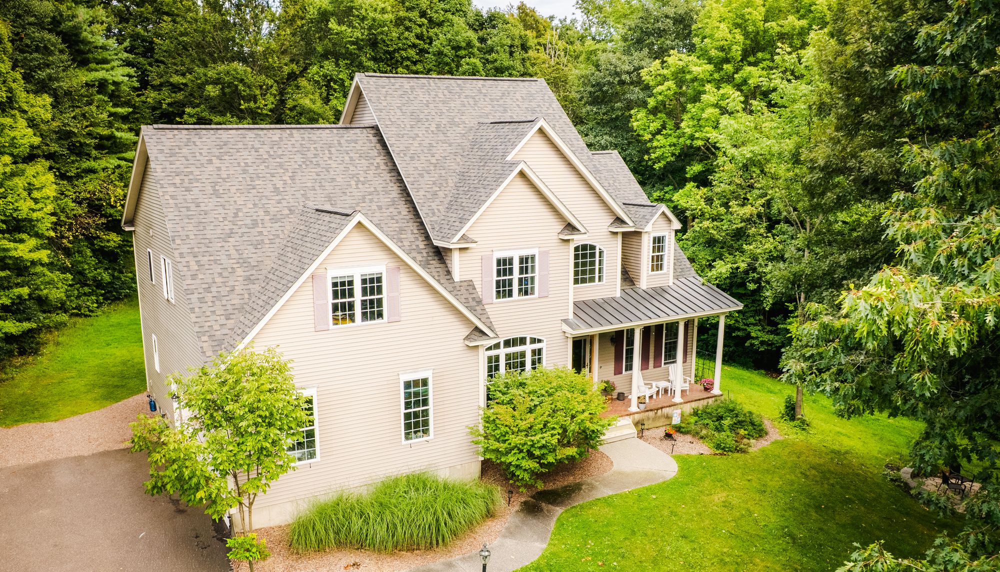 Two-story home with a new architectural shingle roof and standing seam metal porch roof