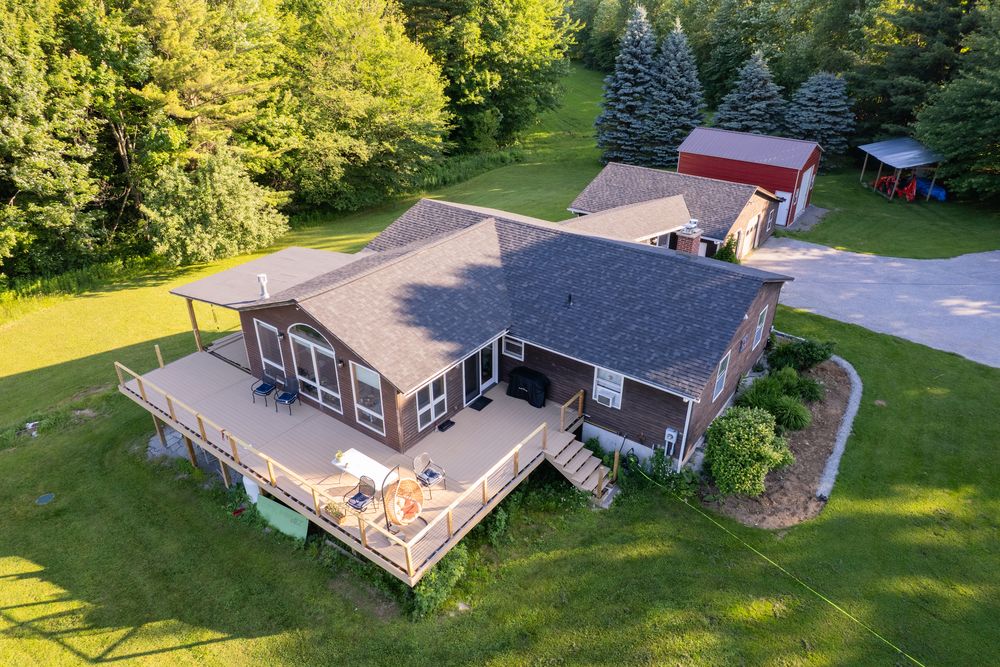 Ranch home with a shingle roof and large deck in Fairfax, Vermont