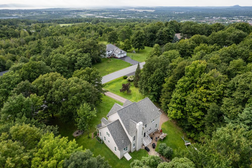 Aerial view of a shingle roof on a wooded lot in Williston, Vermont