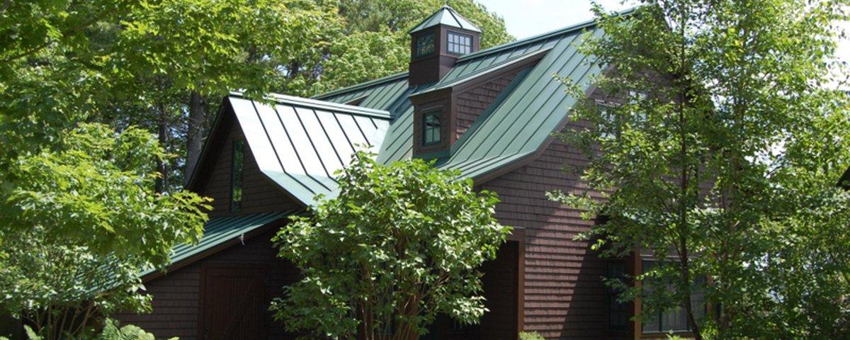 Standing seam metal roof — green panels on Vermont camp