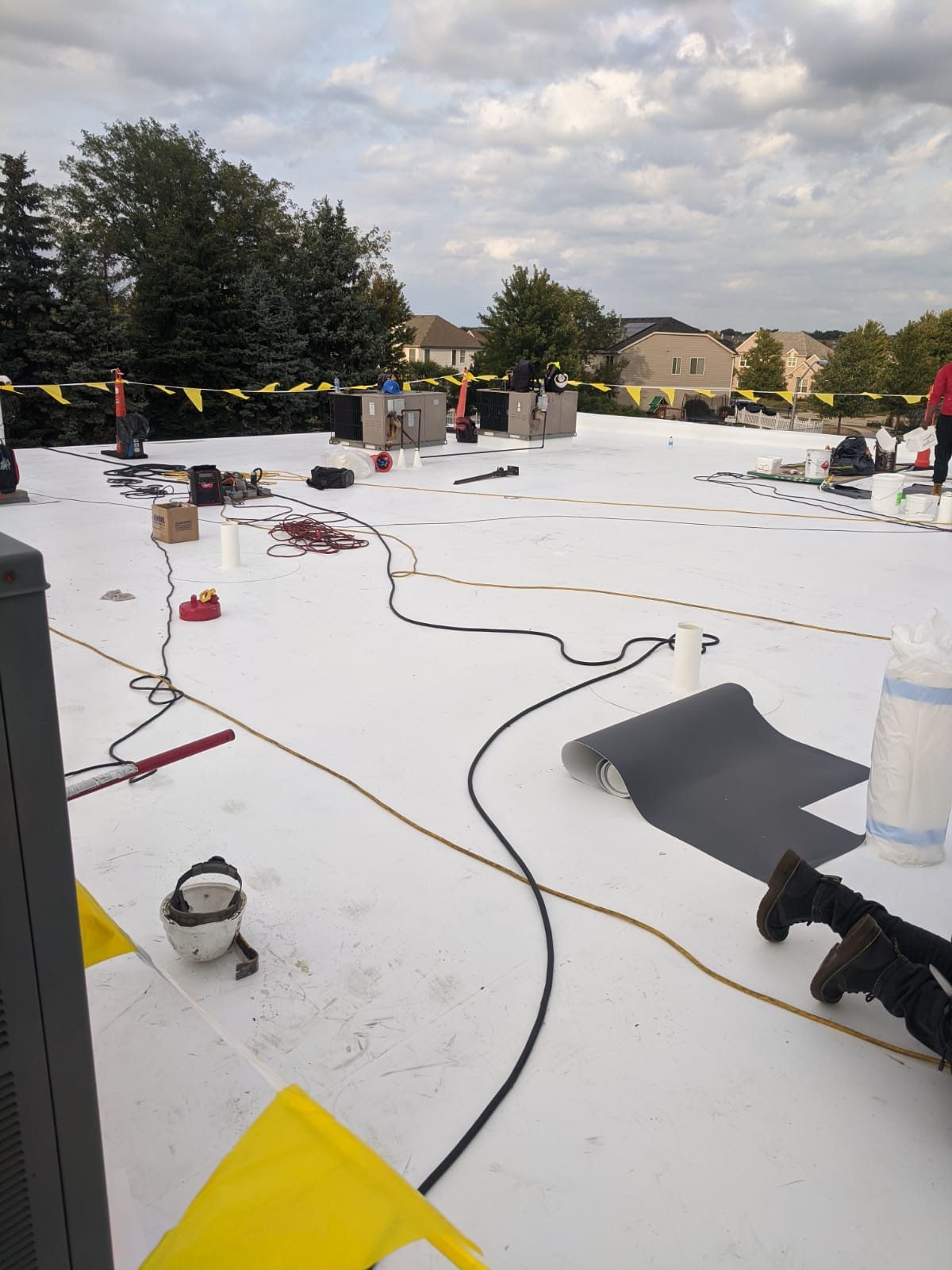 Commercial TPO roofing installation in progress — crew and equipment on flat roof
