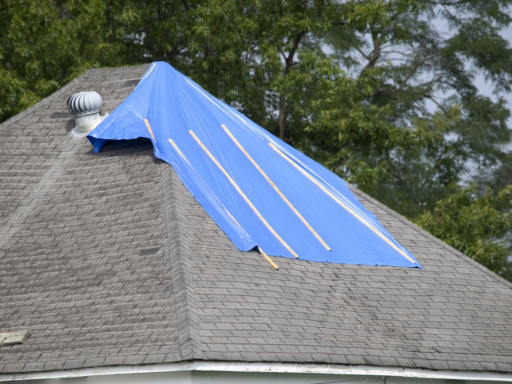 Emergency tarp secured over a damaged section of roof